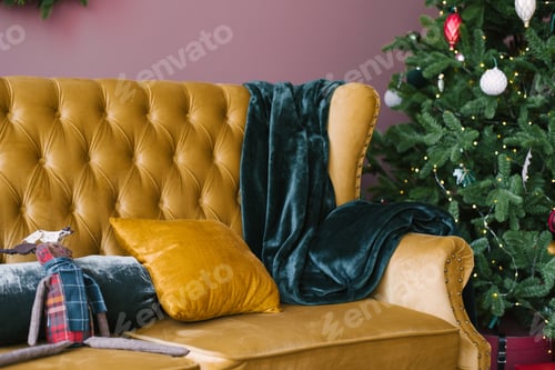 Preview: A yellow pillow and an emerald plaid on a yellow vintage sofa near the Christmas tree in living room