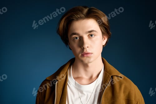 Preview: Young fashionable man poses confidently against a striking blue background