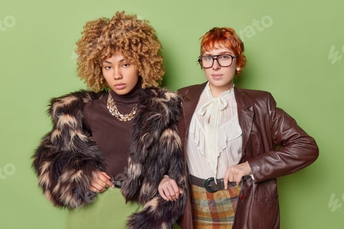 Preview: Horizontal shot of two serious women dressed in old fashioned clothes concentrated at camera have