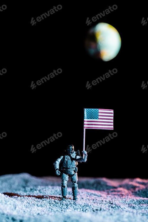 Preview: toy soldier holding national american flag in space with planet Earth on black background