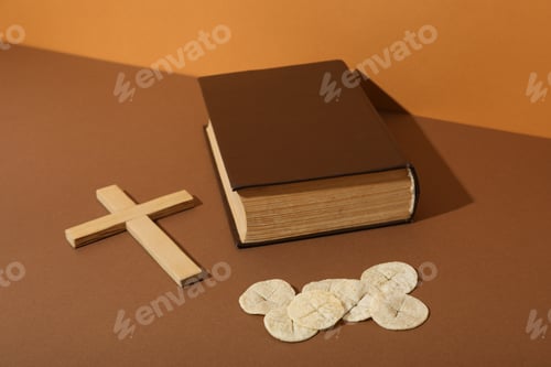 Preview: Wooden cross, book and liturgical bread on brown background