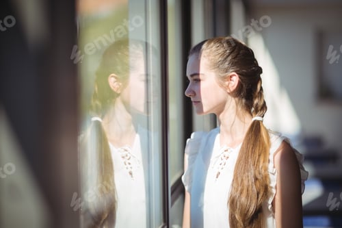 Preview: Schoolgirl looking through window in classroom