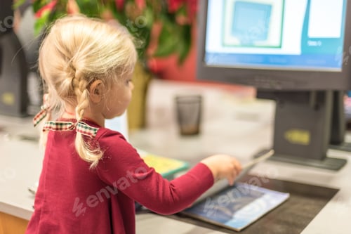 Preview: Young girl checking out library books using a computerized self checkout station