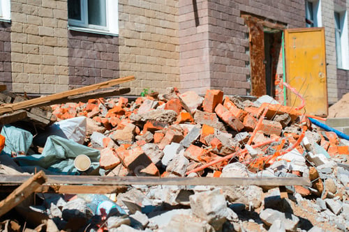 Preview: Landfill, broken old bricks, boards, used materials on the background of a building