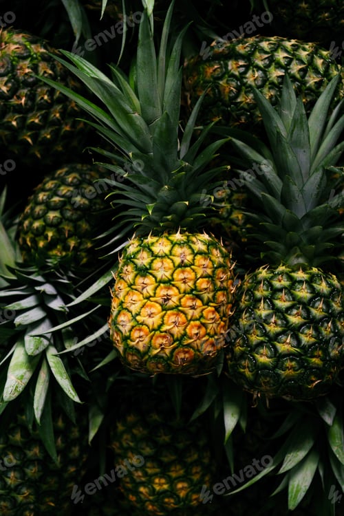 Preview: Vertical closeup shot of fresh pineapples on the dark background