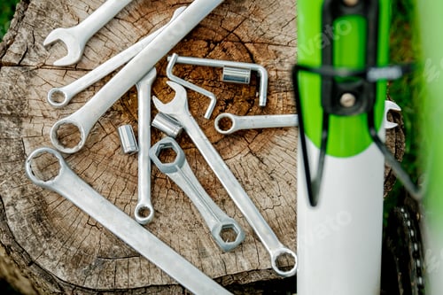 Preview: Tools, instrument for repairing bike on the wooden background outdoor wheel. Bicycle repair.