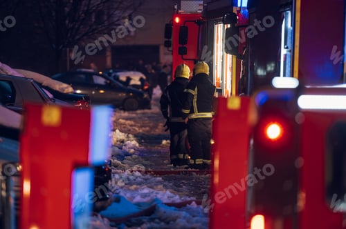 Preview: Firemen at work near their truck on the street.