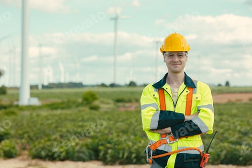 Preview: Smart confident Engineer technician male worker standing at Wind Turbines field