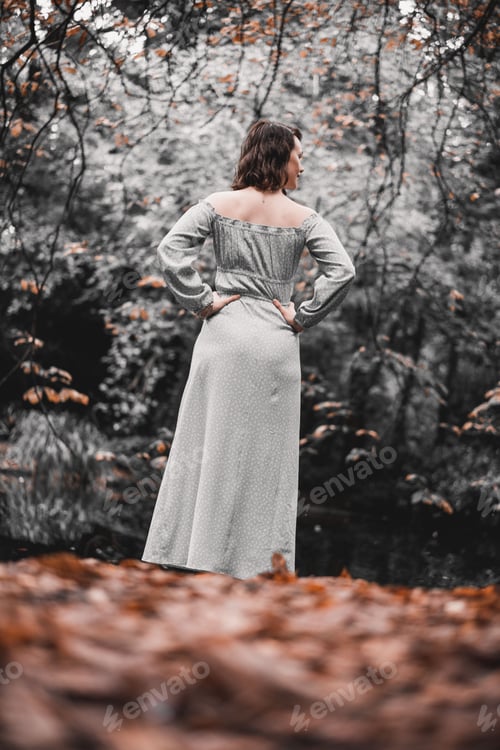 Preview: Woman in a dress stands in an autumn forest