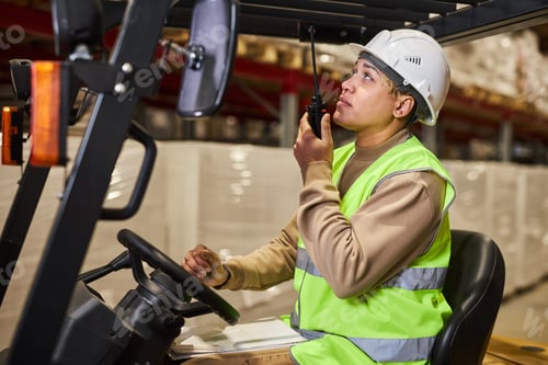 Preview: Female worker operating forklift truck in warehouse