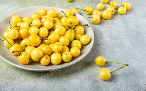 Preview: yellow cherry, cherry berry, scattered on a plate, top view, no people,