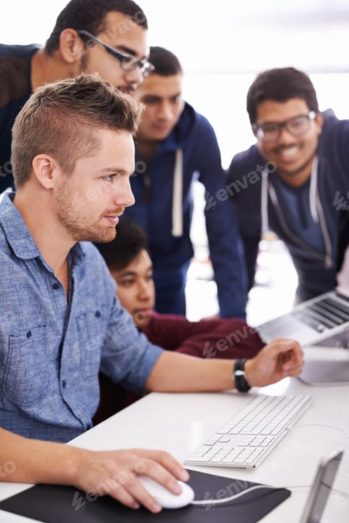 Preview: Cropped shot of young students gathered around a computer