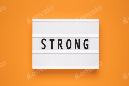 Preview: The word strong on lightbox isolated orange background.