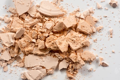 Preview: Close up of broken make up powder on white background.