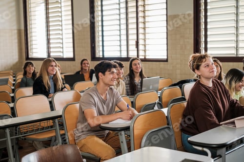 Preview: University students in class attending to the teacher while she explains the lesson