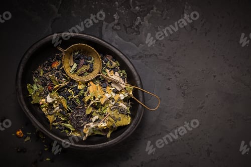 Preview: Mixture of teas, dried organic tea herbs and fruits in bowl with tea strainer