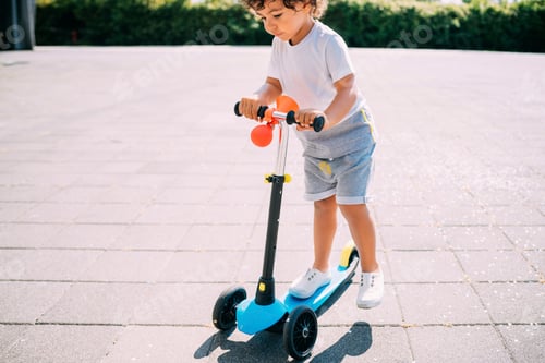 Preview: Toddler riding push scooter in park