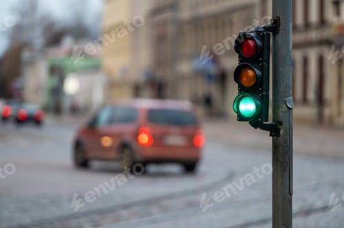 Preview: view of city traffic with traffic lights, in the foreground a semaphore with a green light, closeup