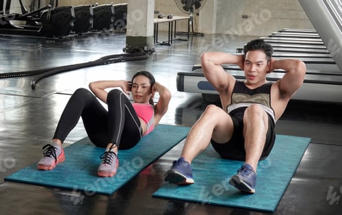Preview: Portrait of woman doing fitness exercises in gym with personal trainer helping her.