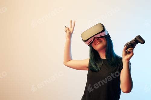 Preview: KYIV, UKRAINE - APRIL 5, 2019: Cheerful brunette woman holding joystick while showing peace sign and