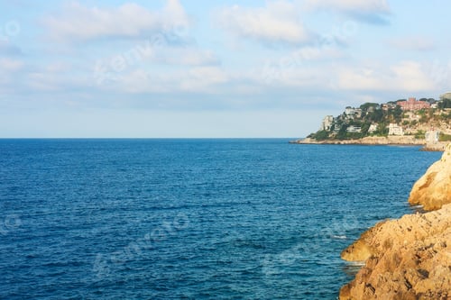 Preview: Picturesque view of sea, city and cliff under blue sky