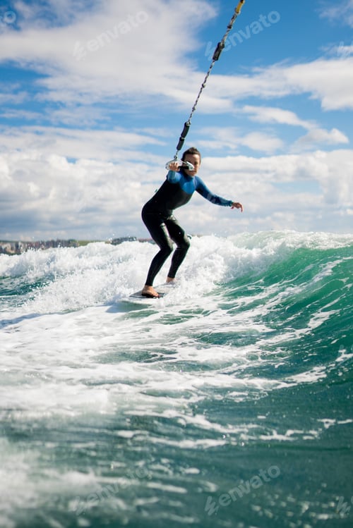 Vorschau: Sportliche Frau beim Wakesurfen auf dem Board am See
