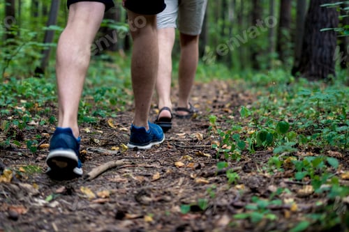 Preview: close up people legs walking in autumn forest on a camping hiking trip