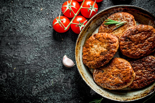 Preview: Cutlets in pan with tomatoes, rosemary and garlic.
