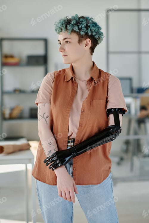 Preview: Young woman with bionic prosthetic arm posing in doctors office