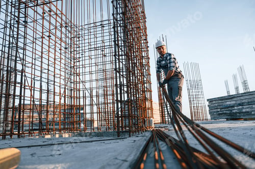 Preview: Working with metal material. Man is on the construction site at daytime
