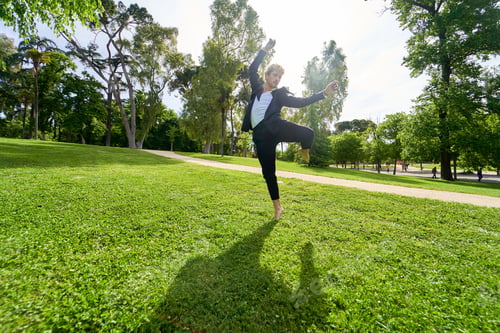 Preview: young man jumping and dancing contemporary ballet in the park with urban costume.