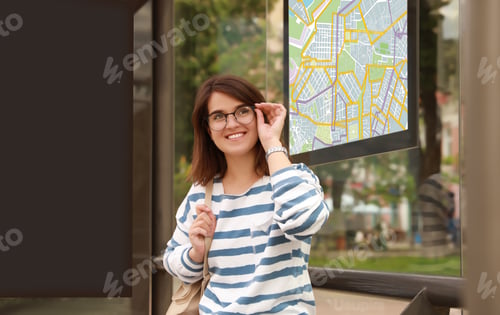 Preview: Young woman waiting for public transport at bus stop