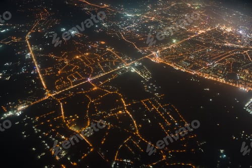 Preview: Aerial view from airplane window of buildings and bright illuminated streets in city residential