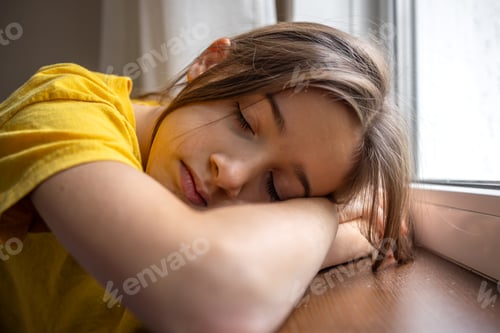 Preview: Sleepy and calm girl near the window. Emotions concept. Drowsiness emotion.