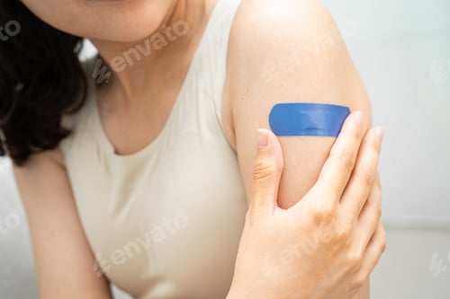 Preview: HPV, Human papillomavirus, Asian young woman receiving vaccine with blue bandage.