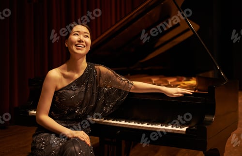 Preview: Shot of a young woman sitting by her piano at the end of a musical concert