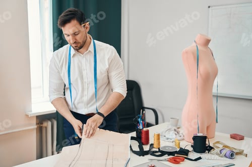 Preview: Male tailor creating new clothing in modern atelier