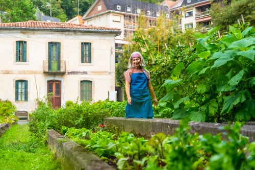 Preview: Woman gardener smiling in raised bed vegetable garden