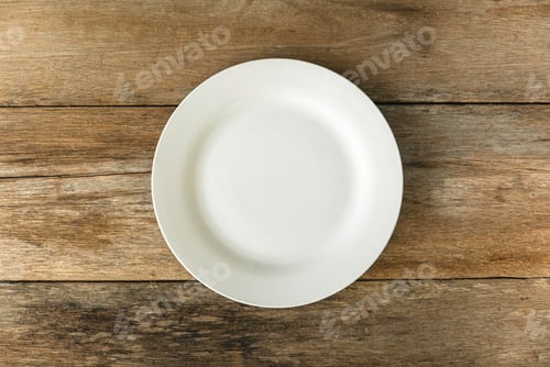 Preview: Top view of empty white plate on a wooden background. Flat lay, copy space.