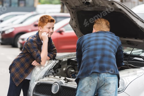 Preview: son looking how father repairing car with open hood
