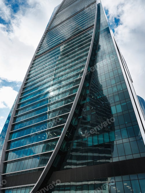Preview: Modern corporate buildings against blue cloud sky.