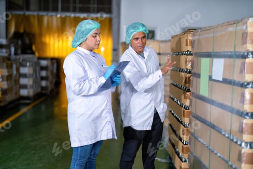 Preview: In warehouse quality control team checking drinking bottle stack on pallet before delivery