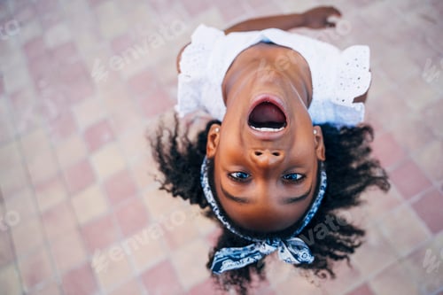 Preview: Cute mixed race girl having fun at street. Child innocence concept.