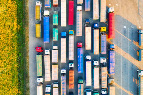 Preview: Aerial view of colorful trucks in terminal at sunset in summer