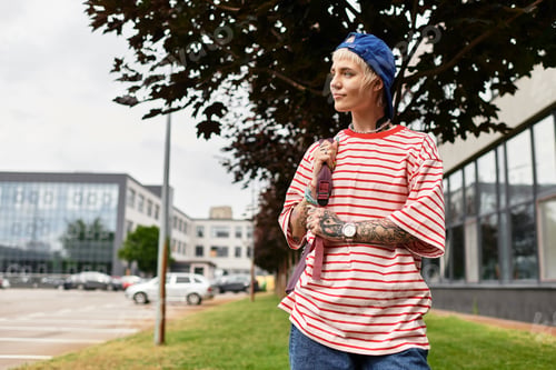 Preview: Stylish young woman enjoying a peaceful afternoon in a vibrant park with modern surroundings