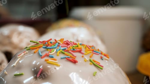 Preview: Close up for freshly baked easter cakes decorated with white glaze and colorful confectionery