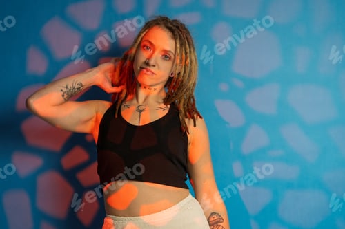 Preview: Woman Posing in Front of Patterned Blue Backdrop