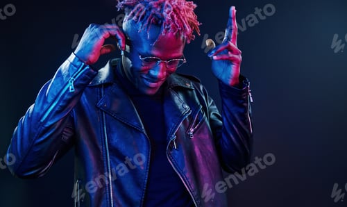 Preview: Having fun. Futuristic neon lighting. Young african american man in the studio
