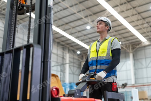 Preview: Man worker driving forklift electric move cardboard boxes sheet goods in paper factory warehouse