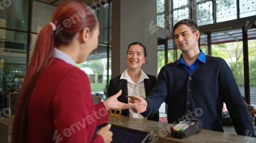 Preview: Customer making payment at hotel reception using credit card terminal